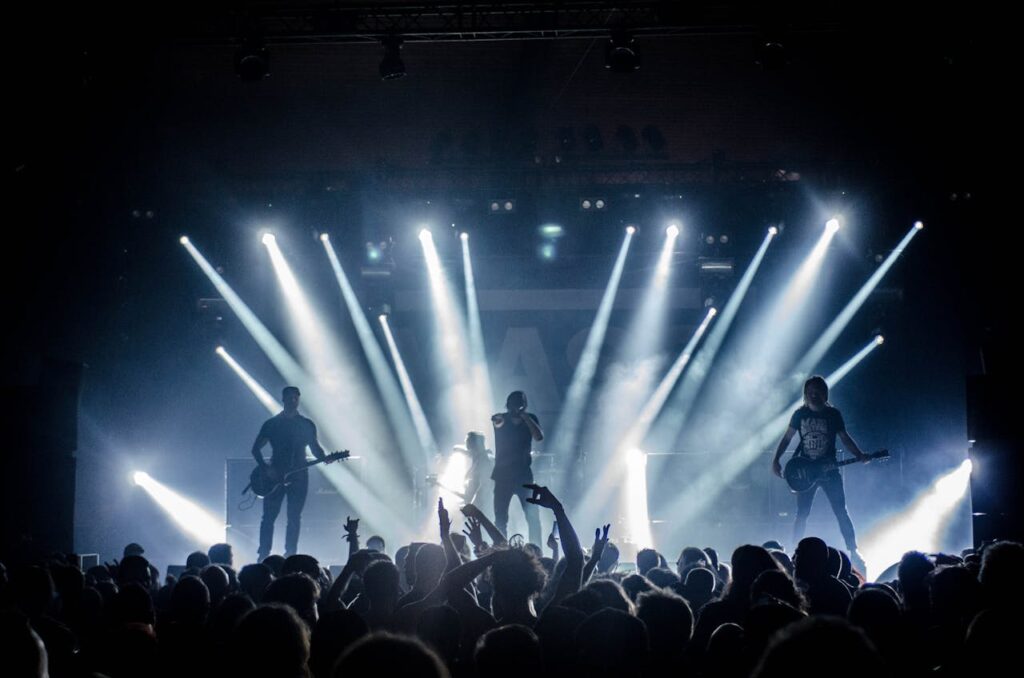 Energetic live concert with musicians performing on stage, engaging the crowd with vibrant lighting effects.